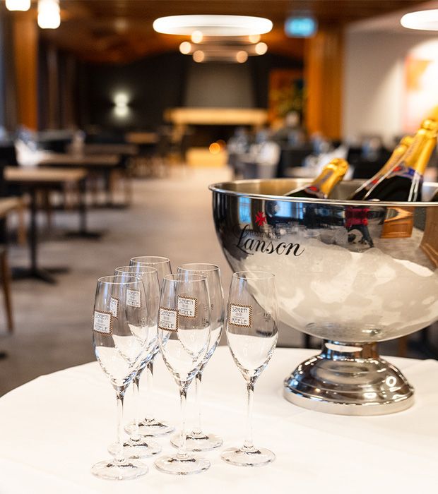 Sektkühler auf weissem Tisch mit Blick ins Restaurant